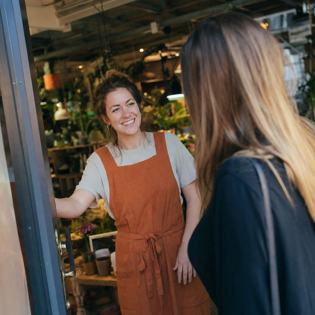 Business owner welcoming a new customer to their business